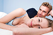 Caucasian couple hugging in bed