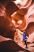 Young Woman Looking Up at Lower Antelope Canyon Walls, Arizona, USA