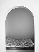 Bed and room seen through an arch