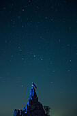 Fliegerdenkmal auf der Wasserkuppe vor Sternenhimmel mit Streifen von einer Sternschnuppe während der Perseiden bei Nacht, nahe Poppenhausen, Rhön, Hessen, Deutschland