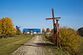 Sculpture on former border patrol path with House on the Border Museum at Point Alpha Memorial in distance