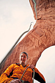 A female climber handles her rope after rappelling off an arch in a remote corner of Utah.