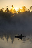 A kayaker enjoys the sunrise as steam rises from Lake Pleasant in Conover, Wisconsin on a brisk fall morning.