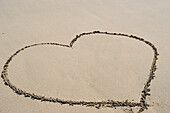 Heart drawn in sand on beach