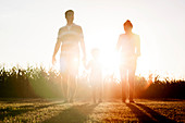 Family with little boy walking together outdoors