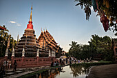 Besucher sitzen im Garten des Tempel Wat Phan Tao, Chiang Mai, Thailand, Südost Asien