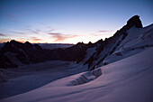 Morning dawn ascending the Barre des Ecrins looking down to Glacier Blanc, Ecrins National Park, Dauphiné, France