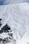An artificially triggered massive avalanche is racing down the full-scale avalanche dynamics test site of the Swiss WSL Institute for Snow and Avalanche Research (SLF), Vallée de la Sionne, Western Bernese Alps, canton of Valais, Switzerland