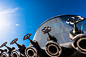 Anschlüsse und Hähne an einem großen silbrigen Tank einer Industrieanlage, Hamburg, Deutschland