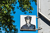Hinweisschild auf eine Kneipe mit Portrait von Volksidol Sänger und Schauspieler Hans Albers an einer Hauswand auf dem Kiez, St. Pauli, Hamburg, Deutschland