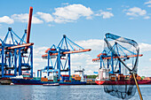 Ships and cranes and a launch during harbour cruise in the harbour container terminal Altenwerder, Hamburg, Germany