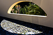 Look trough a wall in a garden with palm trees, Tazacorte, La Palma, Canary islands, Spain