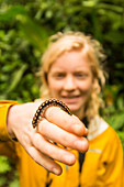 Young girl holds tropical Millipede in the Monteverde cloud forest of Costa Rica