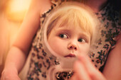 Caucasian preschooler girl examining herself in mirror