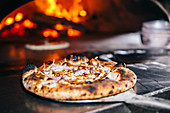 Pizza cooking in wood fired oven