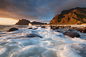 Sonnenuntergang über der Lofoten Insel Vestvågøy mit Blick auf den Strand von Utakleiv und Brandung im Vordergrund, Norwegen, Skandinavien