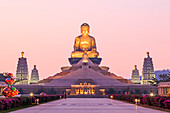 Kaohsiung, Taiwan. Sunset at Fo Guang Shan, the biggest buddist temple of Kaohsiung in Taiwan, with a buddhist monk walking by.