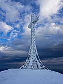 Frozen summit cross of mount Catria in winter at sunset, mount Catria, Marche, Italy