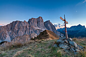 Europe, Italy, Veneto, Cadore.  The summit cross on the Col de la Puina at sunset with mount Pelmo in the background, Dolomites