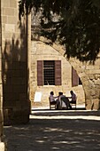 Men eating on a table next to Selimiye Camii Lefkosa, Nicosia, North Cyprus
