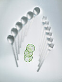 Cutlery under glass with slices of cucumbers