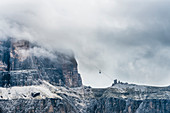 Eine Seilbahn taucht aus den Wolken vom Gebirge am Sellajoch auf, Canazei, Dolomiten, Südtirol, Alto Adige , Italien