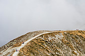 Wanderer auf einem Höhenweg in den Sarntaler Alpen bei aufkommendem Nebel, Meran, Südtirol, Alto Adige , Italien