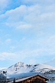 Blick auf den Berghang mit Schwarzhorn und einem Holzschuppen im Vordergrund mit blauen Himmel nach Neuschnee, Radein, Südtirol, Alto Adige, Italien