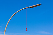 A red analogous telephone receiver hangs on a streetlamp, Hamburg, Germany