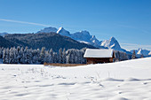 Winterlandschaft mit Heustadel am Geroldsee, Blick auf das Zugspitzmassiv mit Alpspitze, Zugspitze und Waxenstein, Bayern, Deutschland