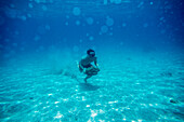 Man walking with stone underwater.