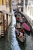 Italy, Venice, gondolas carrying tourists on the canals.