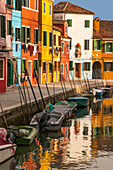 Colored houses facades along a canal , Burano island, Venice, Italy.