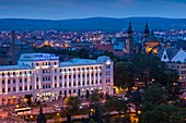 Romania, Transylvania, Sibiu, Piata Unirii Square, elevated view with Hotel Continental Forum, dusk.