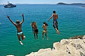 teenagers diving from rocks outside Jezinac beach at the foot of Marjane hill, Split, Croatia, Southeast Europe.