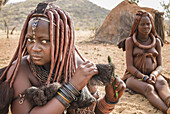 Himba woman combing her hair, village near Epupa falls, Kunene, Namibia, Africa.