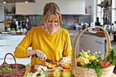 Frau schneidet Gemüse in Küche