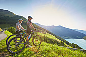 Couple with mountainbike looking in the valley