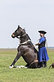 Traditional hungarian cowboy show in the Hortobagy NP. Local cowboy / horseman or Csikos in traditional attire performing for tourists. Europe, Eastern Europe, Hungary, April.