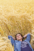 Woman resting in a wheat field. Peñafiel village. Ribera de Duero region. Valladolid. Castile and Leon. Spain, Europe.