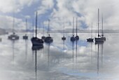 Yacht moorings on a glassy ocean under a cloud-filled sky reflected in the ocean. Saldanha Bay, Western Cape Province, South Africa