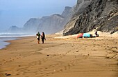 Young people on almost empty beach, Praia da Cordoama, Cordoama beach, near Vila Do Bispo, close to Sagres, Parque Natural do Sudoeste Alentejano e Costa Vicentina, South West Alentejo and Vicentine Coast Natural Park, Western Algarve, Portugal.
