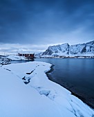 Traditional red seaside Rorbu cabins in winter, Toppøy, Reine Moskenesøy, Lofoten Islands, Norway.