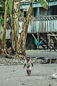 Little child wearing simple clothes walking through a poor area, Sao Tome, Sao Tome and Principe, Africa