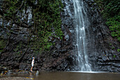 Young woman standing at a waterfall, Sao Tome, Sao Tome and Principe, Africa