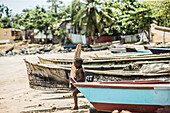 Kleiner einheimischer Junge trägt ein Stück Holz zum Strand, Sao Tome, Sao Tome und Príncipe, Afrika