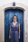 Young woman standing in front of a blue door, Sao Tome, Sao Tome and Principe, Africa