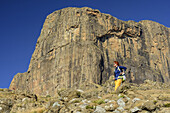 Woman hiking standing in front of Sentinel, Witsieshoek, Amphitheatre, Royal Natal, Drakensberg, uKhahlamba-Drakensberg Park, UNESCO World Heritage Site Maloti-Drakensberg-Park, KwaZulu-Natal, South Africa