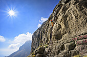 Frau steigt auf Leiter über Felswand hinauf, Sentinel, Witsieshoek, Amphitheatre, Royal Natal, Drakensberge, uKhahlamba-Drakensberg Park, UNESCO Welterbe Maloti-Drakensberg-Park, KwaZulu-Natal, Südafrika