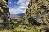 Frau beim Wandern in Orange Peel Gap, Cathedral Peak, Mlambonja Wilderness Area, Drakensberge, uKhahlamba-Drakensberg Park, UNESCO Welterbe Maloti-Drakensberg-Park, KwaZulu-Natal, Südafrika